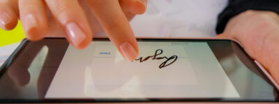 Macro Digital Signature on smartphone screen with finger. Sign Document Deal at Work Office Indoors. Electronic signature.