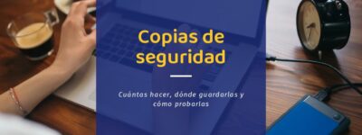 Copias de seguridad para empresas: disco duro externo conectado por USB a un portátil en una mesa de trabajo